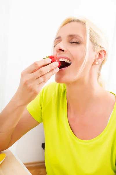 Mulher madura, comendo morango — Fotografia de Stock